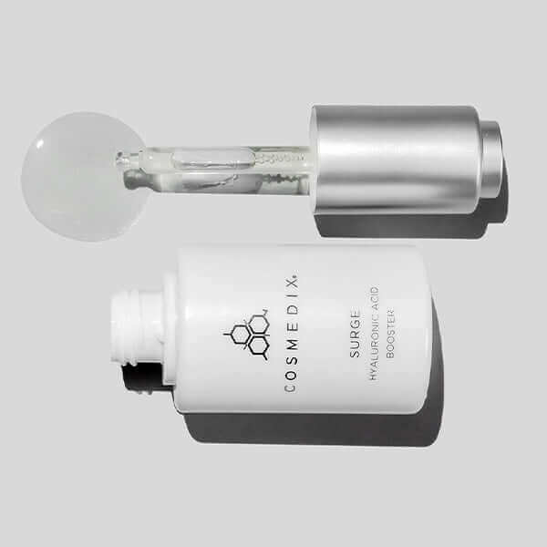 A bottle on it side and a dropper with serum coming out of  it. It is a Hyaluronic Acid booster serum